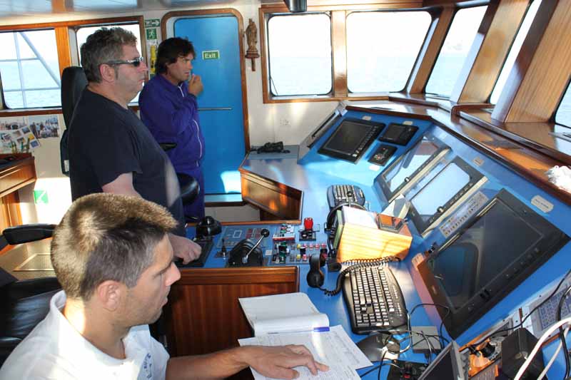 El Capitán del B/O Emma Bardán, en el puente de gobierno, controlando la navegación. A su derecha el Primer Oficial y a su izquierda el Jefe de Máquinas. Puede comprobarse la amplitud del puente, su luminosidad y la gran visibilidad que posee ©IEO