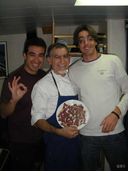 El director del laboratorio gastronómico de a bordo, Emilio Marín, flanqueado por Gerardo Bruque y Antonio Torres, que se mantienen vigilantes ante los platos de jamón ibérico de la muy antigua región de Onubia ©IEO